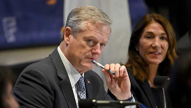 Charlie Baker listens to a presentation.